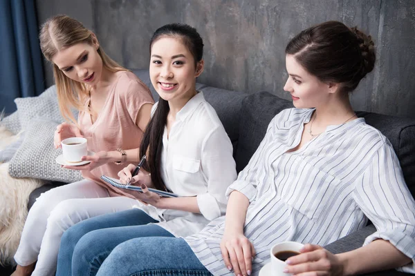 Menulis gadis sementara teman-teman minum kopi — Stok Foto