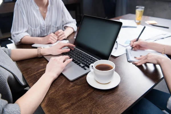 Las mujeres de negocios que trabajan con el ordenador portátil y taza de café —  Fotos de Stock