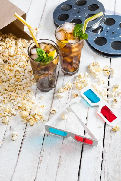 Popcorn with iced tea and film reels — Stock Photo