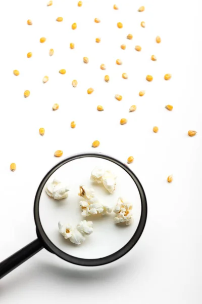 Popcorn and magnifying glass — Stock Photo