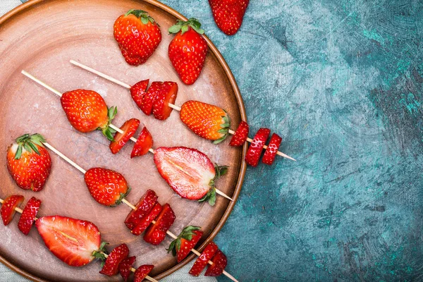 Strawberries on wooden skewers — Stock Photo