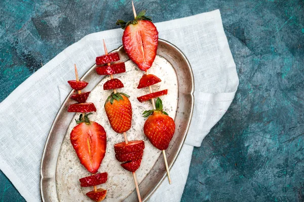 Strawberries on wooden skewers — Stock Photo