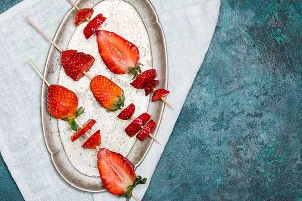 Strawberries on wooden skewers — Stock Photo