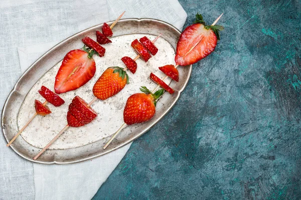 Strawberries on wooden skewers — Stock Photo