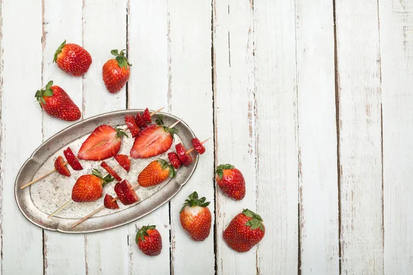 Strawberries on wooden skewers — Stock Photo