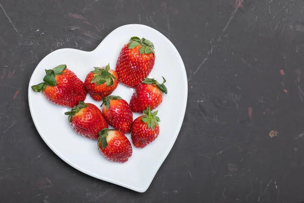 Strawberries on heart shaped plate — Stock Photo