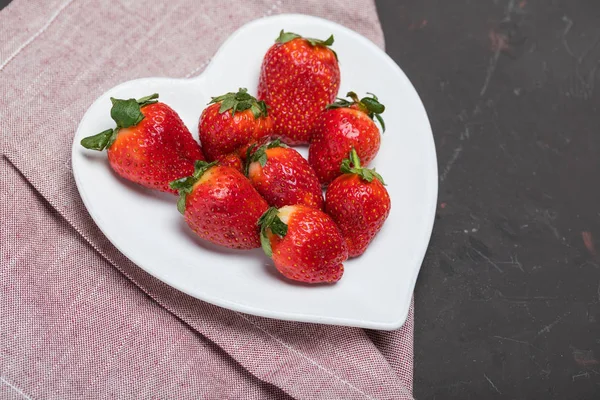 Strawberries on heart shaped plate — Stock Photo