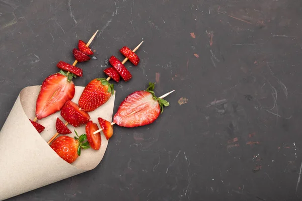 Strawberries on wooden skewers — Stock Photo