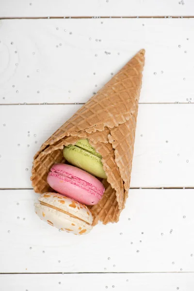 Colorful macarons in waffle cones — Stock Photo