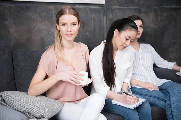 Mädchen schreibt, während Freunde Kaffee trinken — Stockfoto