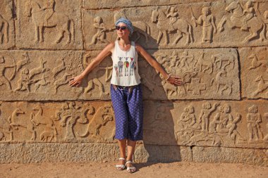 Kraliyet muhafaza içinde Hampi. Genç bir kızın oyulmuş taş ve oymalar Hampi içinde bir arka plan üzerinde duruyor. Vijayanagar, İstanbul, unesco.