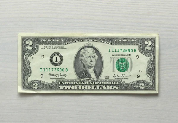 Zwei Dollar mit einem Schein. 2 Dollar mit einer Banknote. — Stockfoto