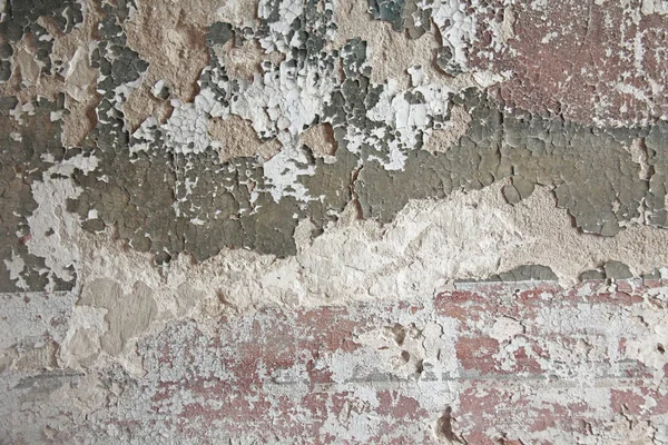 Pared de ladrillo. Vieja pintura blanca escamosa que se desprende de una grumosa pared agrietada. Grietas, raspaduras, pelado de pintura vieja y yeso en el fondo de la pared de cemento viejo. Una vieja pared de piedra de cemento como agrietado vintage. — Foto de Stock