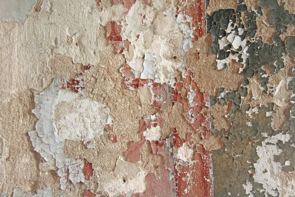 Régi pelyhes fehér festékkel peeling ki egy szutykos repedt fal. Repedések, karcolások, peeling régi festék és a vakolat, a háttérben a régi cement-fal. Egy régi cement kőfal, vintage repedt. — Stock Fotó