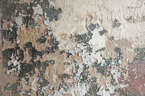 Téglafal. Régi fehér festék lehámlik egy koszos repedt falról. Repedések, horzsolások, régi festék és vakolat hámlása a régi cementfal hátterén. Egy régi cementfal, mint a régi repedt. — Stock Fotó