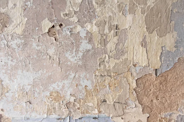 Téglafal. Régi fehér festék lehámlik egy koszos repedt falról. Repedések, horzsolások, régi festék és vakolat hámlása a régi cementfal hátterén. Egy régi cementfal, mint a régi repedt. — Stock Fotó