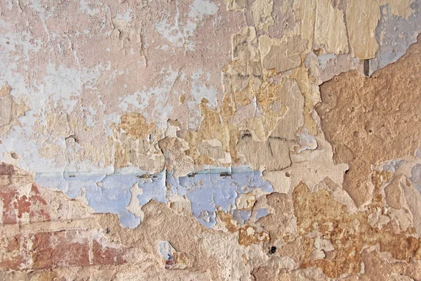 벽돌 벽. 낡은 하얀 페인트가 울퉁불퉁 한 벽에서 벗겨져 나가고 있다. 선반, 긁힌 자국, 오래 된 페인트 와 석고를 오래 된 시멘트 벽을 배경으로 벗긴다. 포도를 수확 할 때 사용 했던 오래 된 시멘트 석벽. — 스톡 사진