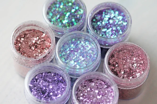 Multi-colored Sequins for the design of nails in a box. Glitter in jars. Foil for nail service. Photo set. Sparkling beauty shimmer, glitter.