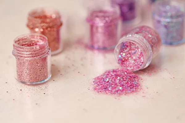 Pink Sequins for the design of nails in a box. Glitter in jars. Foil for nail service. Photo set. Sparkling beauty shimmer, glitter.