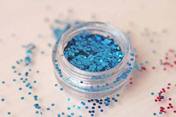 Blue Sequins for the design of nails in a box. Glitter in jars. Foil for nail service. Photo set. Sparkling beauty shimmer, glitter.