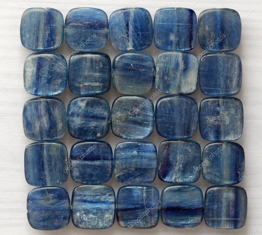 Photo beads of natural stone Kyanit. Natural mineral blue kyanite on a white wooden background