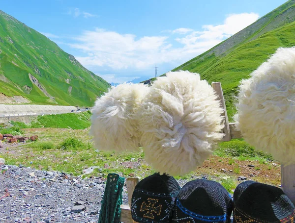 Koyun Yeşil dağlar ve mavi gökyüzü arka plan üzerinde beyaz şapka yapılmış — Stok fotoğraf