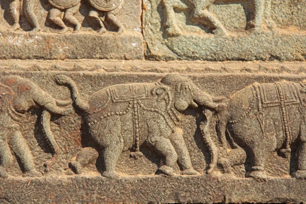 Stone bas-reliëfs op de muren in tempels Hampi. Snijwerk de steen oude achtergrond. Gesneden figuren gemaakt van steen. UNESCO World Heritage Site. Karnataka, India. Koninklijke bijlage. — Stockfoto