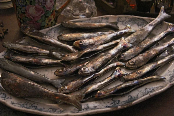 A small fish lies on a plate. Photo made in vintage store, Croatia — Stock Photo, Image