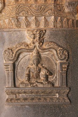 Tapınak Hampi sütununda taş bas-reliefs. Oyma taş antik arka plan. Taştan oyulmuş resimler. UNESCO dünya mirası. Karnataka, Hindistan. Taş arka plan. Siyah bazalt.