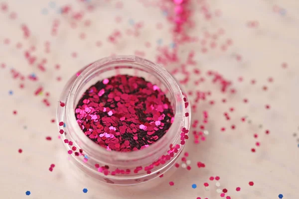 Pink Sequins for the design of nails in a box. Glitter in jars. Foil for nail service. Photo set. Sparkling beauty shimmer, glitter.