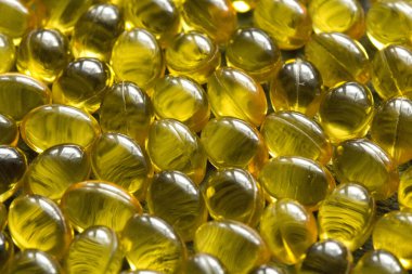 Altın siyah arka plan kapsülleri gıda takviye kapsüllerini kapatın. A vitamini, D3 vitamini, balık yağı, Omega 3, 6, 9, çuha çiçeği yağı, keten tohumu yağı, D vitamini, E vitamini..