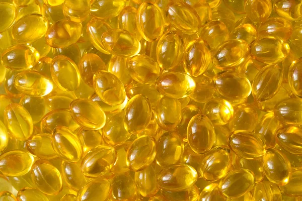 Golden background capsules Close up food supplement oil filled capsules suitable vitamin A, vitamin D3, fish oil, omega 3, 6, 9, evening primrose, borage oil, flax seeds oil, vitamin D, vitamin E.