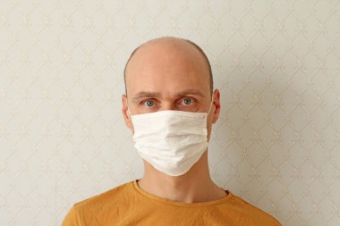 Tıbbi maskeli genç adam. Enfeksiyonu önlemek için hijyenik maske takan adam, grip gibi hava yoluyla bulaşan solunum hastalığı, Covid - 2019. Koronavirüse karşı koruma, bulaşıcı hastalıklar, virüsler..