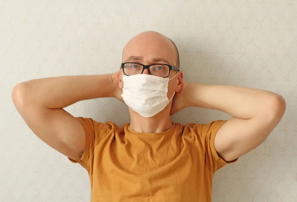 Young Man in medical mask, glasses. Man wearing hygienic mask to prevent infection, airborne respiratory illness such as flu, Covid - 2019. Protection against coronavirus, contagious disease, viruses.