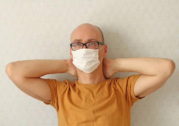 Young Man in medical mask, glasses. Man wearing hygienic mask to prevent infection, airborne respiratory illness such as flu, Covid - 2019. Protection against coronavirus, contagious disease, viruses.