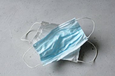 İki tıbbi maske. Kauçuk kulaklıklı cerrahi maske. Ağız ve burnu örtmek için tipik 3 katlı cerrahi maske. Bakterilerin prosedür maskesi. Koruma konsepti. Koronavirüse karşı koruma.