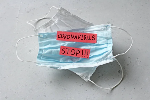 Two Medical mask which word Coronavirus is written. Surgical used mask with rubber ear straps. Typical 3-ply surgical mask cover mouth, nose. Procedure mask bacteria. Protection against coronavirus.