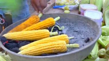 Sarı mısır fırında ya da kömürde kızartılır. Hindistan 'da sokak yemeği. Mısırlı barbekü..