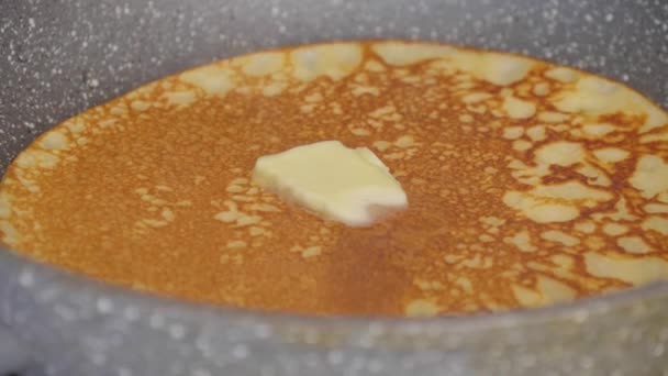 バターの一片はロシアのパンケーキの上にあり ゆっくりと加熱されます ロシアの伝統的なパンケーキは グリッド上で焼き上げられ クローズアップを生成します おいしいロシアのパンケーキを調理 — ストック動画
