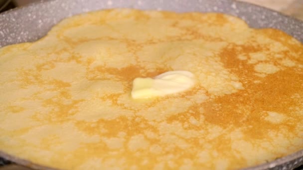 バターの一片はロシアのパンケーキの上にあり ゆっくりと加熱されます ロシアの伝統的なパンケーキは グリッド上で焼き上げられ クローズアップを生成します おいしいロシアのパンケーキを調理 — ストック動画