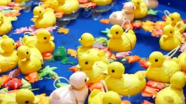Sarı plastik ördek oyuncakları mavi suyun arka planında şişme havuzda yüzerler. En sevdiği çocuk oyunu, sudan ördek yakalamak. Çocuk eğlence parkı. Hipnoz, baş dönmesi.