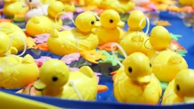 Sarı plastik ördek oyuncakları mavi suyun arka planında şişme havuzda yüzerler. En sevdiği çocuk oyunu, sudan ördek yakalamak. Çocuk eğlence parkı. Hipnoz, baş dönmesi.