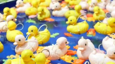 Sarı plastik ördek oyuncakları mavi suyun arka planında şişme havuzda yüzerler. En sevdiği çocuk oyunu, sudan ördek yakalamak. Çocuk eğlence parkı. Hipnoz, baş dönmesi.