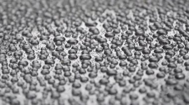 Gri Arkaplanda Su Damlaları. Yakın plan. Su damlacıkları arka planda. Gri ya da siyah metal bir arabanın çatısına güzel bir yoğunlaştırılmış su damlası düşer..