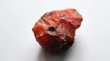 Kornelian taşı doğal bir taş mineralidir. Gri arkaplanda doğal taşlardan oluşan bir kolleksiyondur. Dönen güzel bir kornelik taşı. Doğal mineral kaba kornelian değerli taş kristali