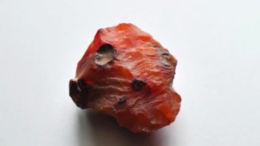 Kornelian taşı doğal bir taş mineralidir. Gri arkaplanda doğal taşlardan oluşan bir kolleksiyondur. Dönen güzel bir kornelik taşı. Doğal mineral kaba kornelian değerli taş kristali