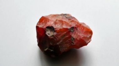 Kornelian taşı doğal bir taş mineralidir. Gri arkaplanda doğal taşlardan oluşan bir kolleksiyondur. Dönen güzel bir kornelik taşı. Doğal mineral kaba kornelian değerli taş kristali