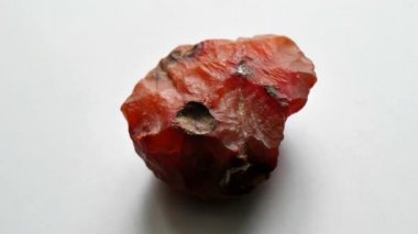 Kornelian taşı doğal bir taş mineralidir. Gri arkaplanda doğal taşlardan oluşan bir kolleksiyondur. Dönen güzel bir kornelik taşı. Doğal mineral kaba kornelian değerli taş kristali