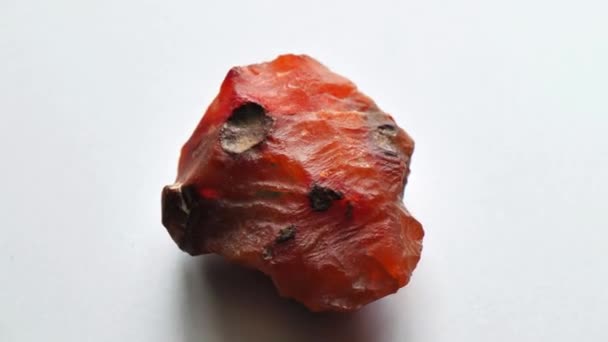コーネリアン石は天然石の鉱物で 灰色の背景に天然石のコレクションです 美しい石のコーネリアン回転 回転します 天然鉱物ラフコーネリアン宝石クリスタル — ストック動画