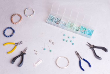 El yapımı mücevherler. Üst Manzara. Boncuklar, mücevher yapmak için aletler. El yapımı için hazırlık. Doğal taşlardan kendi ellerinle mücevher ve bilezikler yarat. Düz yatıyordu. Beyaz arkaplanda.